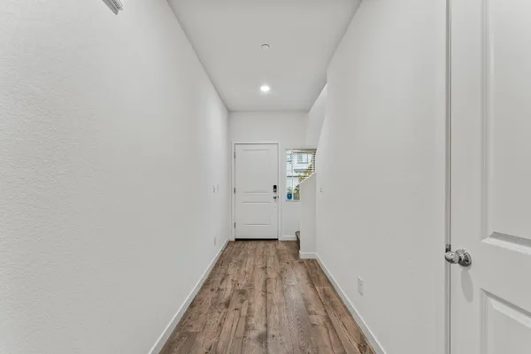 a view of a hallway with wooden floor