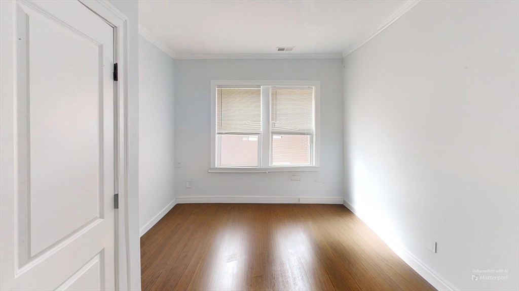 2969 Washington Street, Unit 2 Boston, MA 02119 - Photo 3 of 7 an empty room with wooden floor and windows