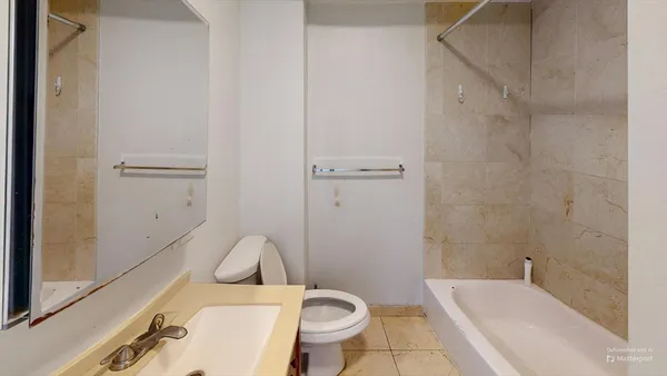 a white toilet sitting next to a bath tub