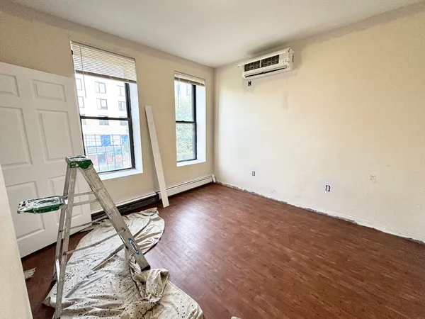 a view of a livingroom with wooden floor and a window