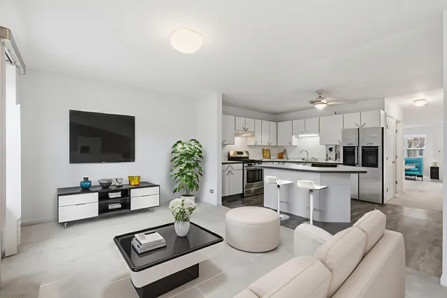 a living room with furniture a flat screen tv and kitchen view