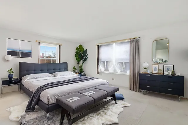 a bedroom with a bed window and a mirror