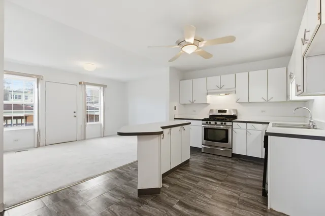 a kitchen with granite countertop white cabinets and white appliances