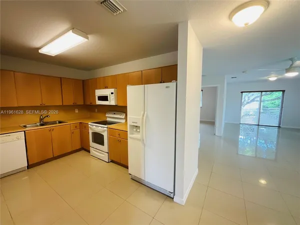 a kitchen with a refrigerator sink and cabinets