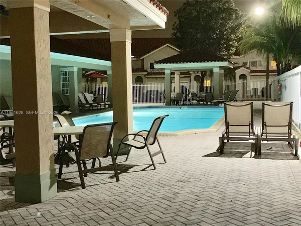 a view of a house with backyard and sitting area