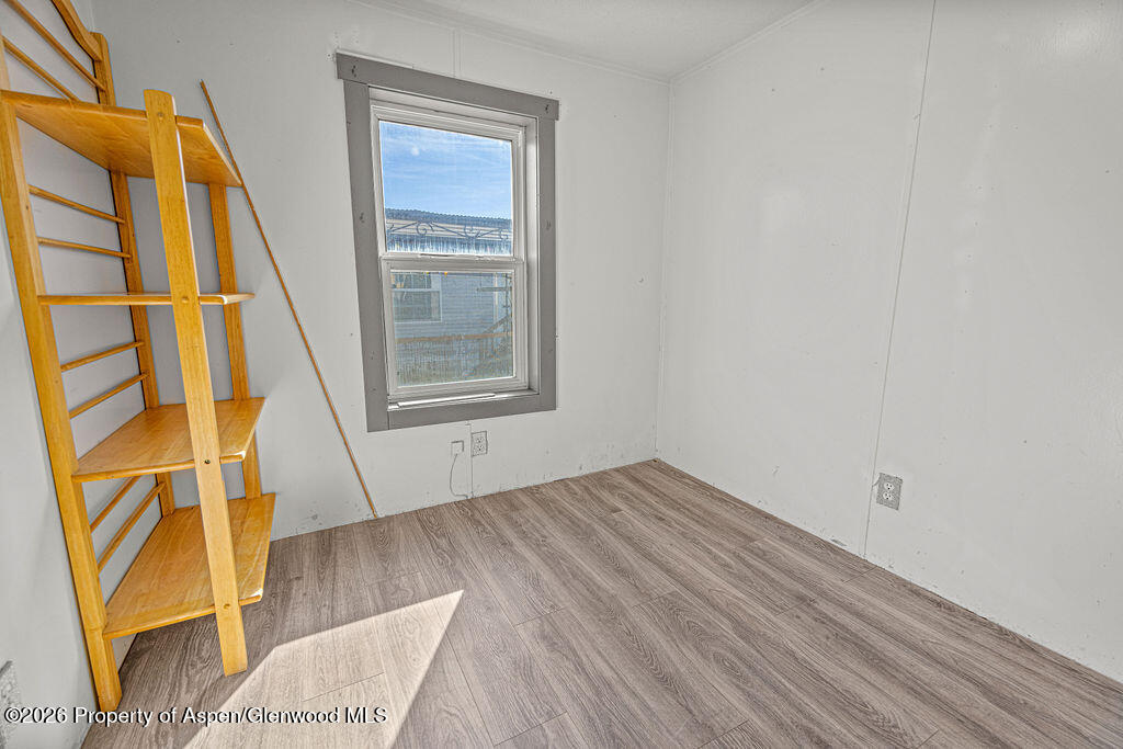 2210 West 3rd Street, Unit 38 Craig, CO 81625 - Photo 15 of 22 a view of an empty room with wooden floor and a window