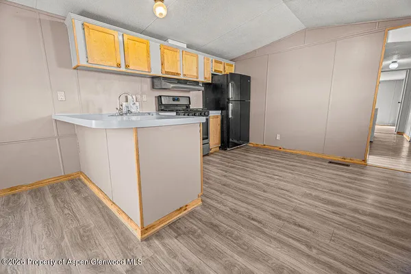 a kitchen with stainless steel appliances a refrigerator and a stove top oven