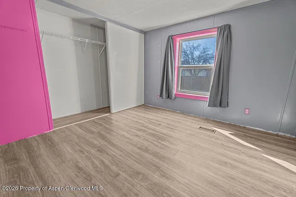 a view of empty room with window and wooden floor