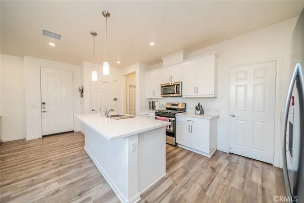 a kitchen with white cabinets and white appliances