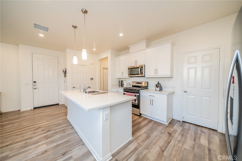 214 Bonita Lane Rialto, CA 92376 - Photo 13 of 51 a kitchen with white cabinets and white appliances