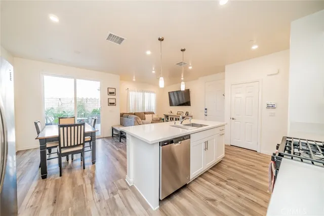 a large kitchen with a table chairs wooden floor and a window
