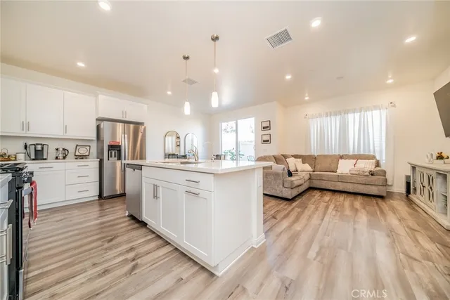 a kitchen with white cabinets and stainless steel appliances