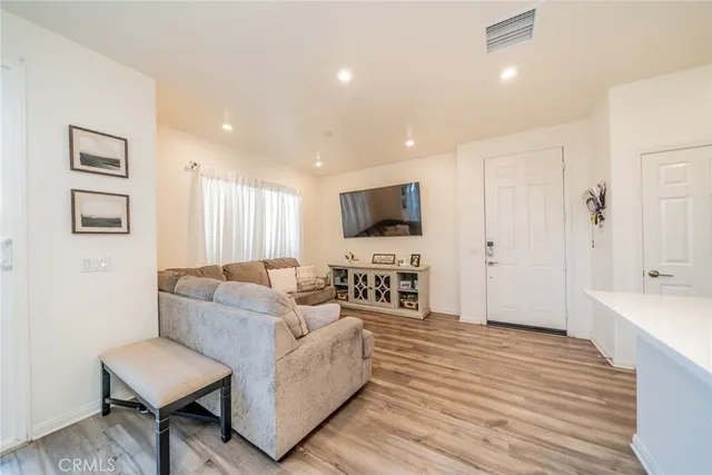 a living room with furniture a flat screen tv and kitchen view