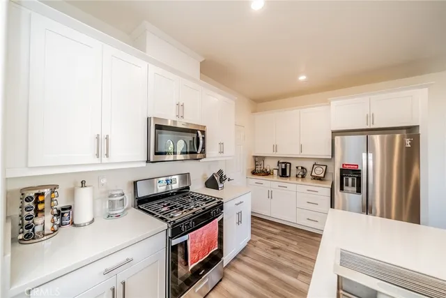 a kitchen with granite countertop a sink stove and refrigerator
