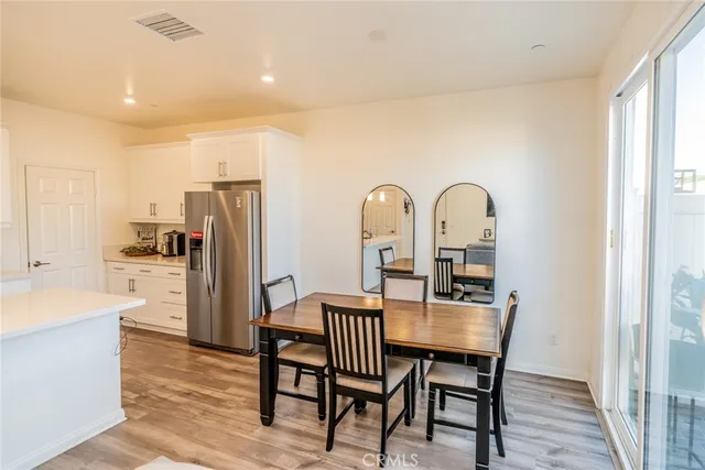 a view of a dining room with furniture a rug and wooden floor