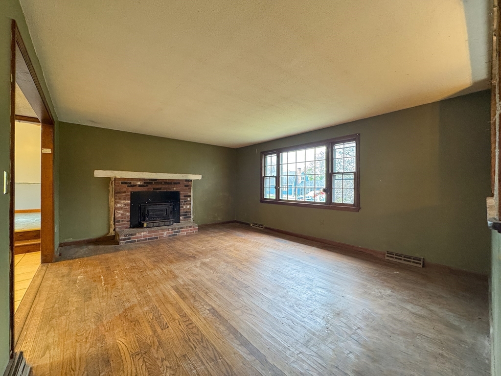60 White Fox Road Feeding Hills, MA 01030 - Photo 9 of 29 a view of an empty room with a fireplace and a window