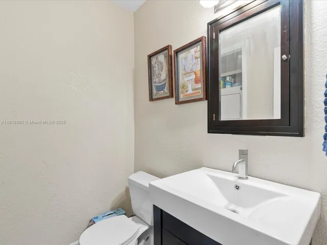 a bathroom with a toilet a sink and mirror