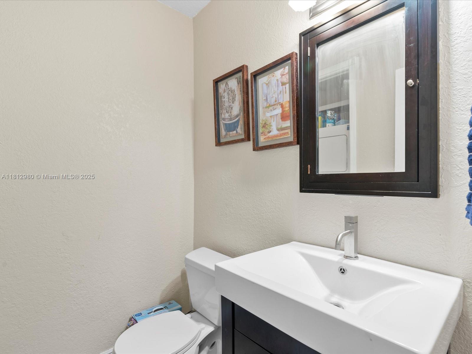 3097 Bird Avenue, Unit 3097 Miami, FL 33133 - Photo 12 of 29 a bathroom with a toilet a sink and mirror