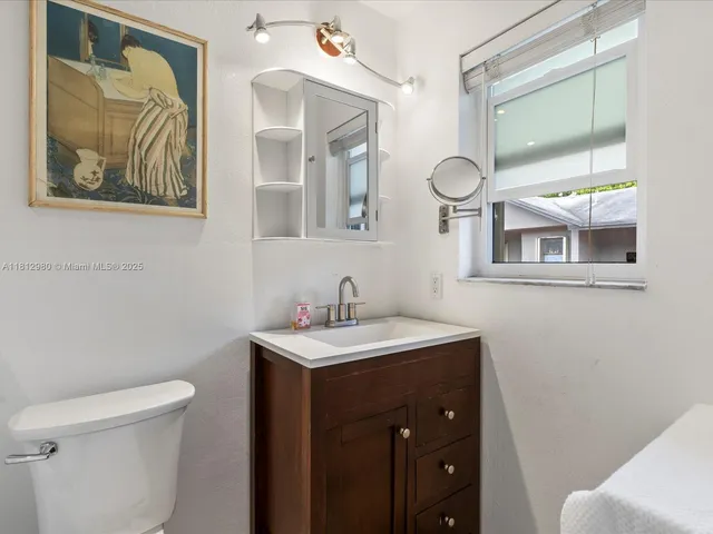 a bathroom with a toilet a sink and mirror