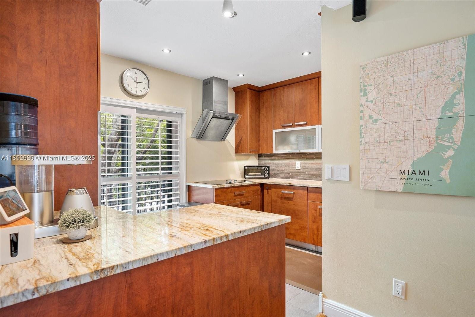 3097 Bird Avenue, Unit 3097 Miami, FL 33133 - Photo 7 of 29 a kitchen with granite countertop sink and stove