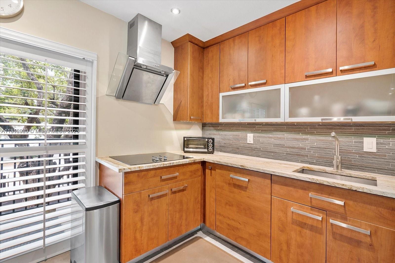 3097 Bird Avenue, Unit 3097 Miami, FL 33133 - Photo 9 of 29 a kitchen with stainless steel appliances granite countertop a sink stove and cabinets