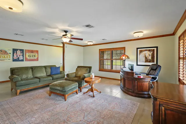 a living room with furniture ceiling fan and a window