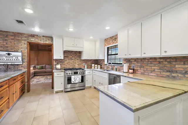 a kitchen with stainless steel appliances granite countertop a stove sink and cabinets