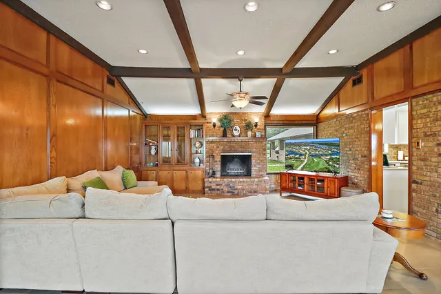 a living room with furniture a large window and a fireplace