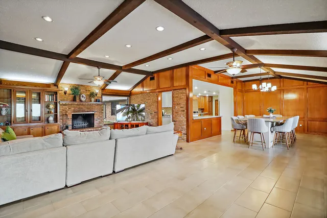 a living room with furniture a fireplace and dining table