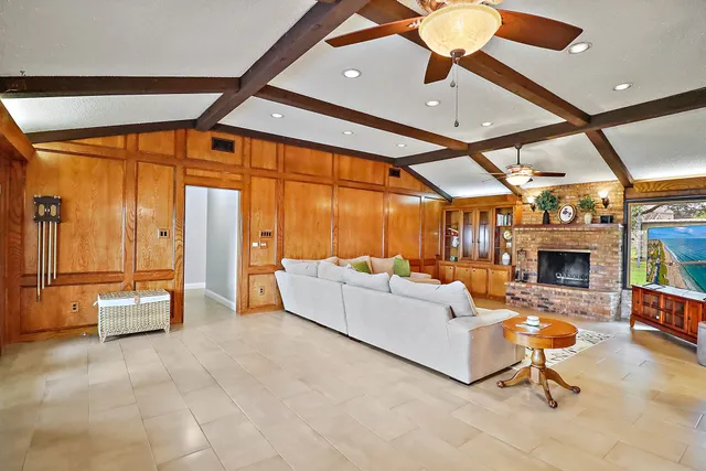 a living room with furniture a fireplace and a large window