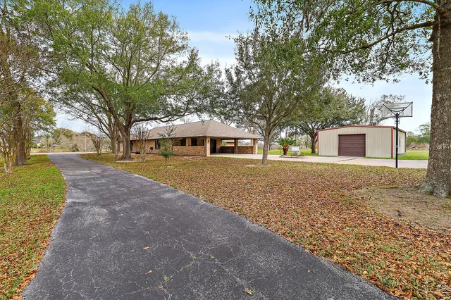 a front view of a house with a yard and trees