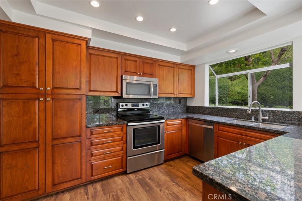 14 Pickney Close Laguna Niguel, CA 92677 - Photo 18 of 22 a kitchen with stainless steel appliances granite countertop a stove a sink dishwasher a microwave oven with cabinets and wooden floor