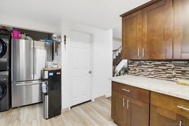 a kitchen with granite countertop a refrigerator and wooden floor