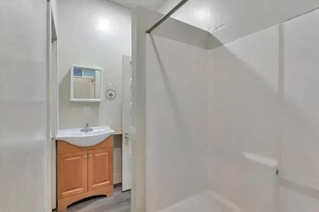 a bathroom with a sink a mirror and shower