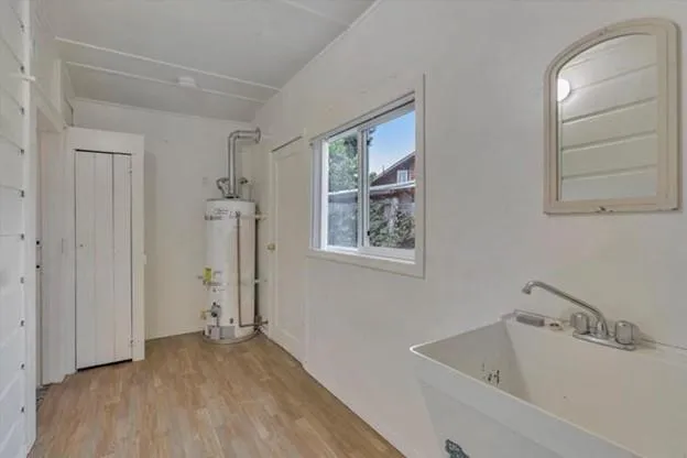 a view of a room that has a sink and a wooden floor