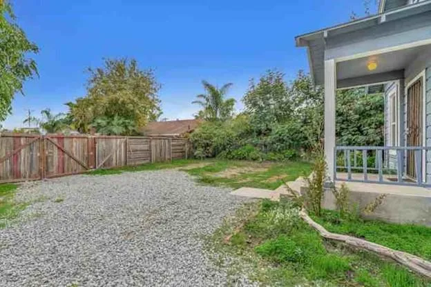 a view of a backyard with wooden fence