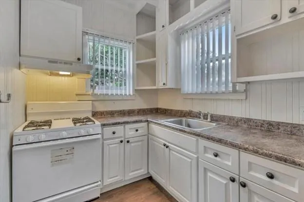 a kitchen with cabinets appliances a sink and a window