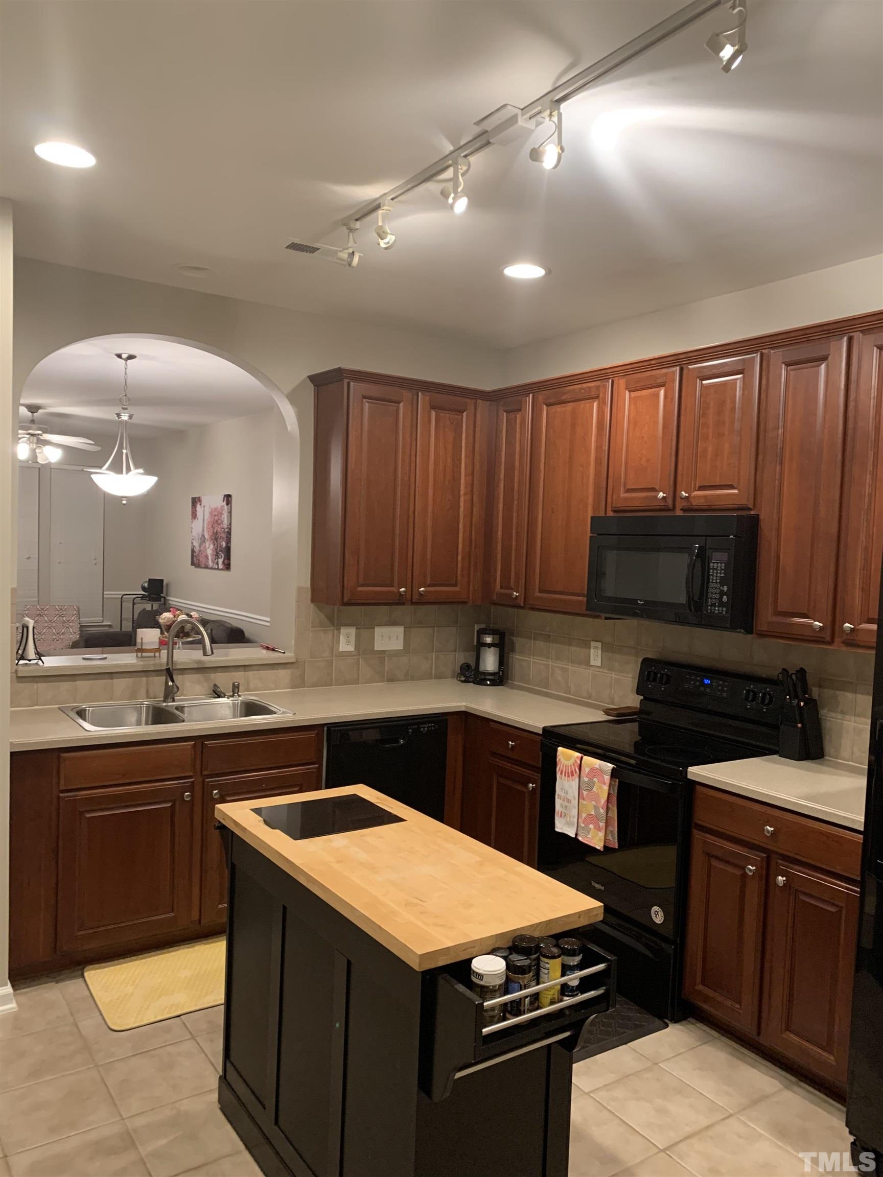 7845 Spungold Street Raleigh, NC 27617 - Photo 11 of 37 a kitchen with stainless steel appliances granite countertop wooden cabinets a stove a sink and a oven