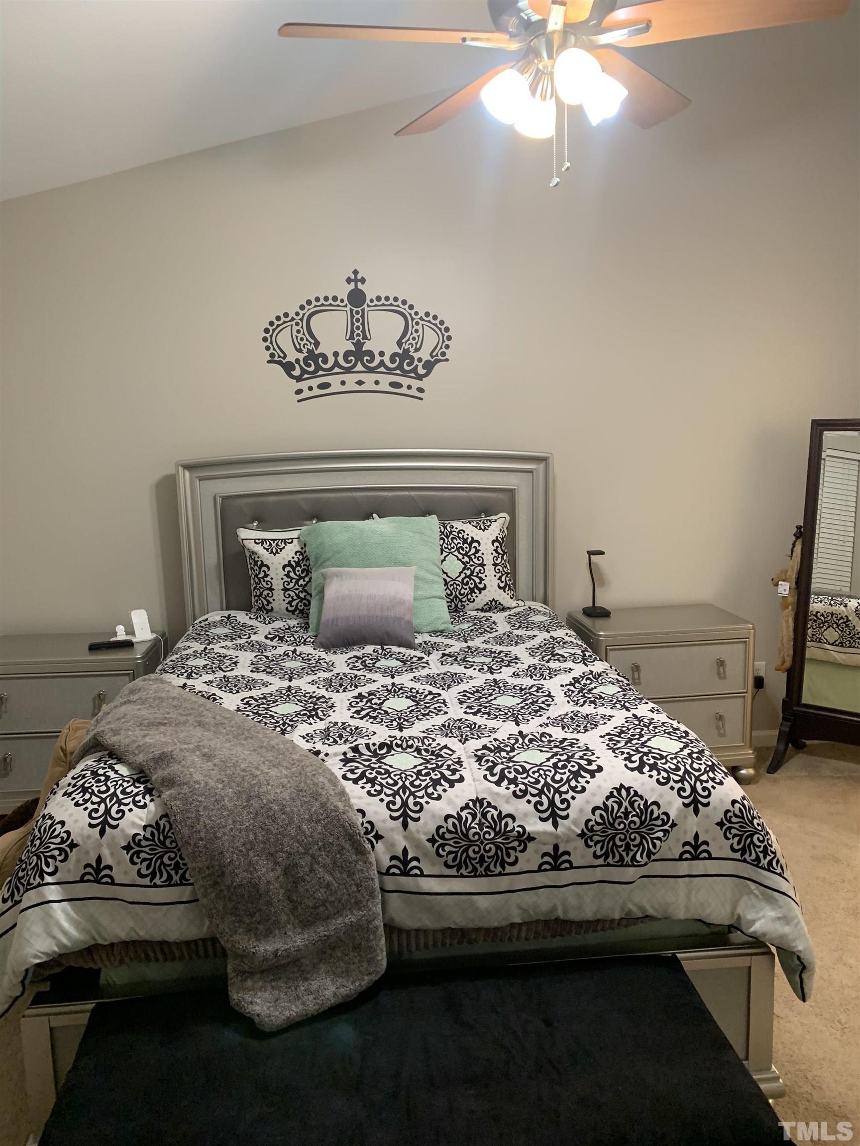 7845 Spungold Street Raleigh, NC 27617 - Photo 17 of 37 a bedroom with a bed and a chandelier