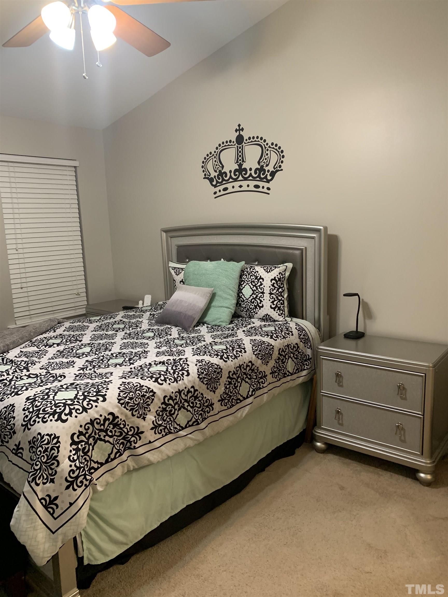 7845 Spungold Street Raleigh, NC 27617 - Photo 18 of 37 a bedroom with a bed and a chandelier