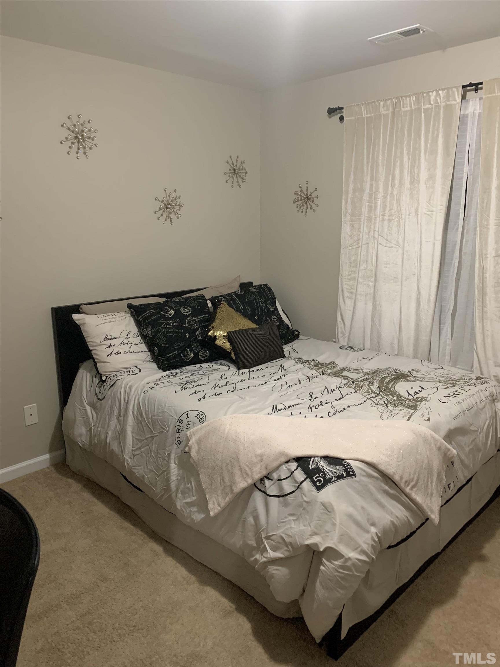 7845 Spungold Street Raleigh, NC 27617 - Photo 29 of 37 a bedroom with a bed and curtain