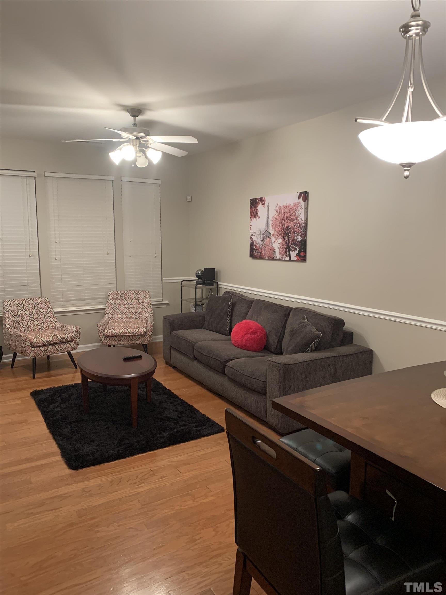 7845 Spungold Street Raleigh, NC 27617 - Photo 7 of 37 a living room with furniture and a chandelier