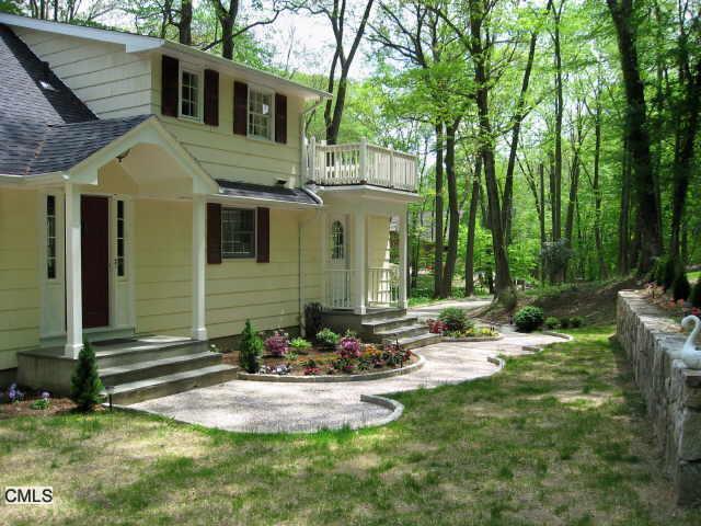 a view of a house with backyard and sitting area