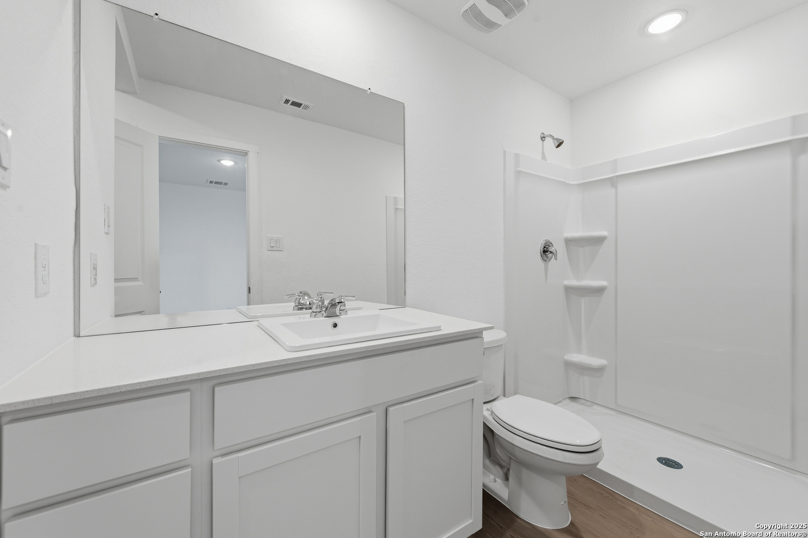 11814 Bluebell Ridge Converse, TX 78109 - Photo 14 of 20 a bathroom with a toilet a sink a mirror a shower and vanity