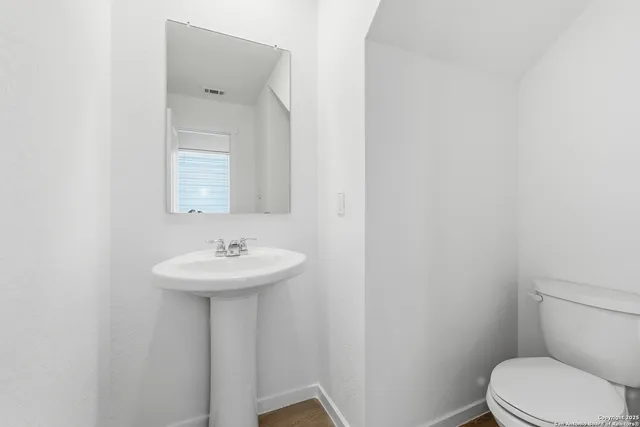 a bathroom with a sink a toilet and mirror