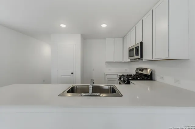 a kitchen with a sink a stove and cabinets