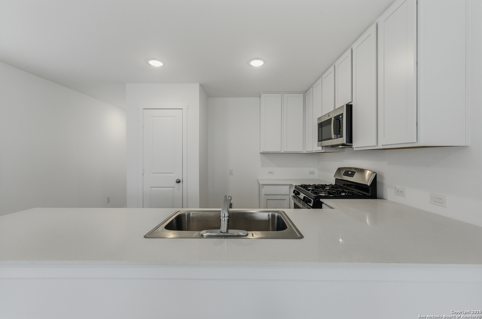 11814 Bluebell Ridge Converse, TX 78109 - Photo 7 of 20 a kitchen with a sink a stove and cabinets