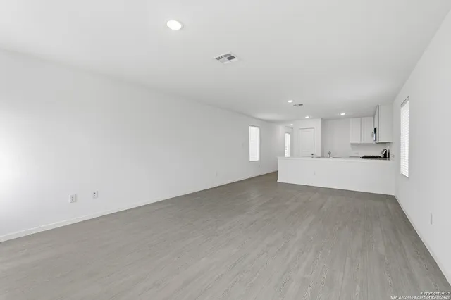 a view of a big room with wooden floor and windows