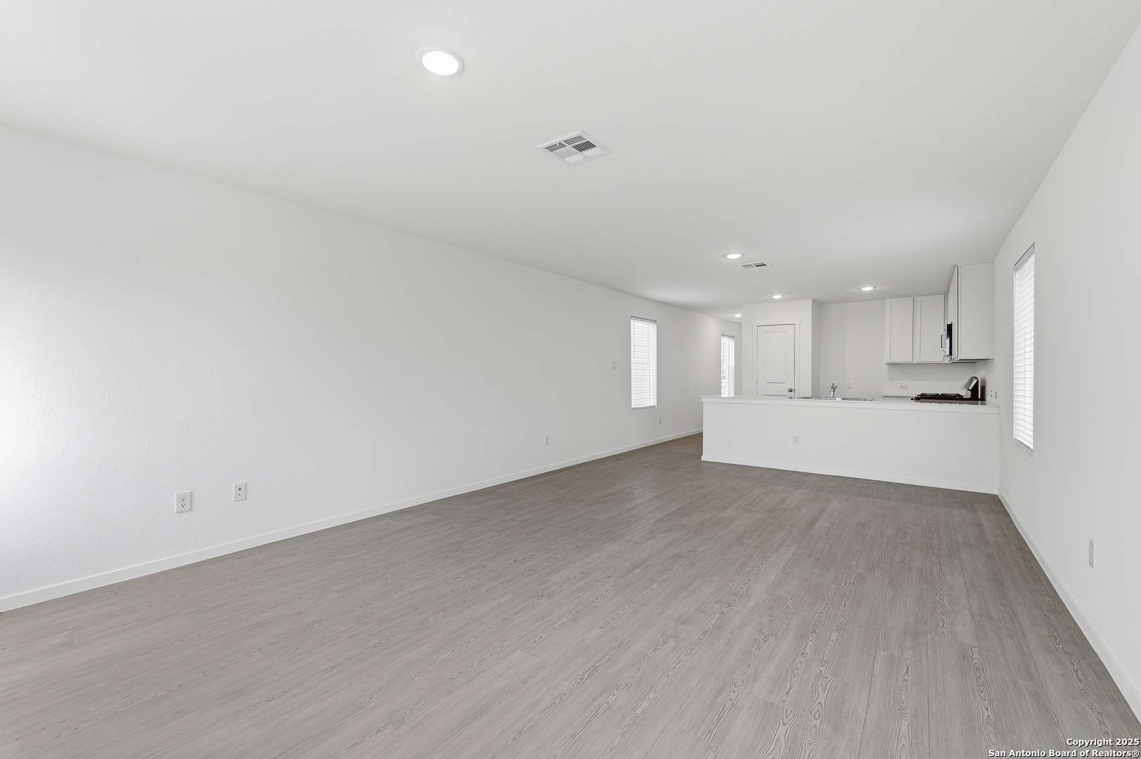 11814 Bluebell Ridge Converse, TX 78109 - Photo 10 of 20 a view of a big room with wooden floor and windows