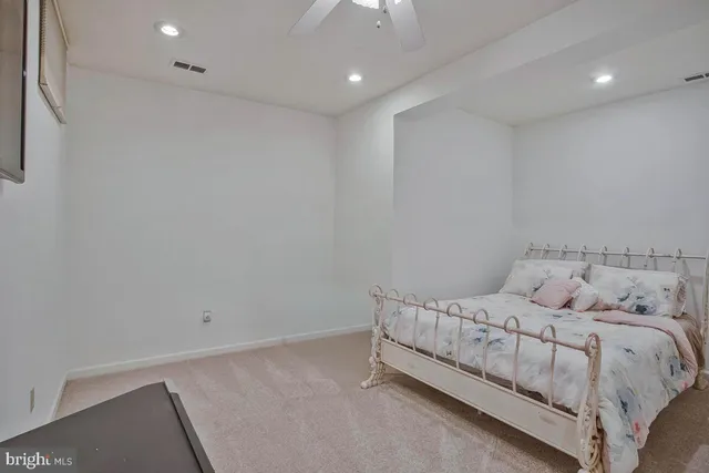 a large bed sitting in a room next to a lamp